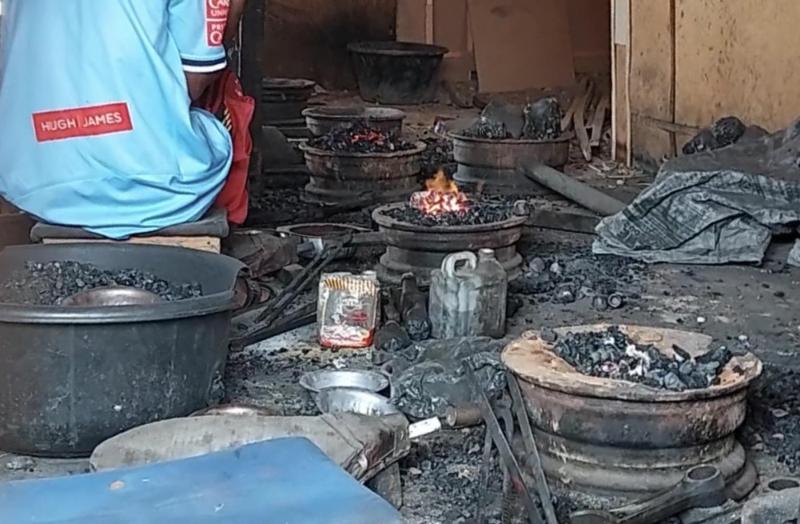 Gusau Zamfara Un orfevre est assis pres fourneau interieur du marche de Polo