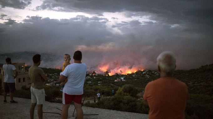 Des habitants observent depuis Rafina un incendie