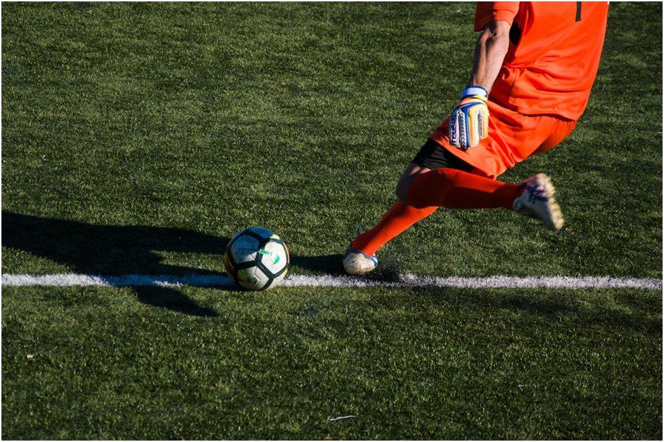 un homme qui frappe un ballon de football